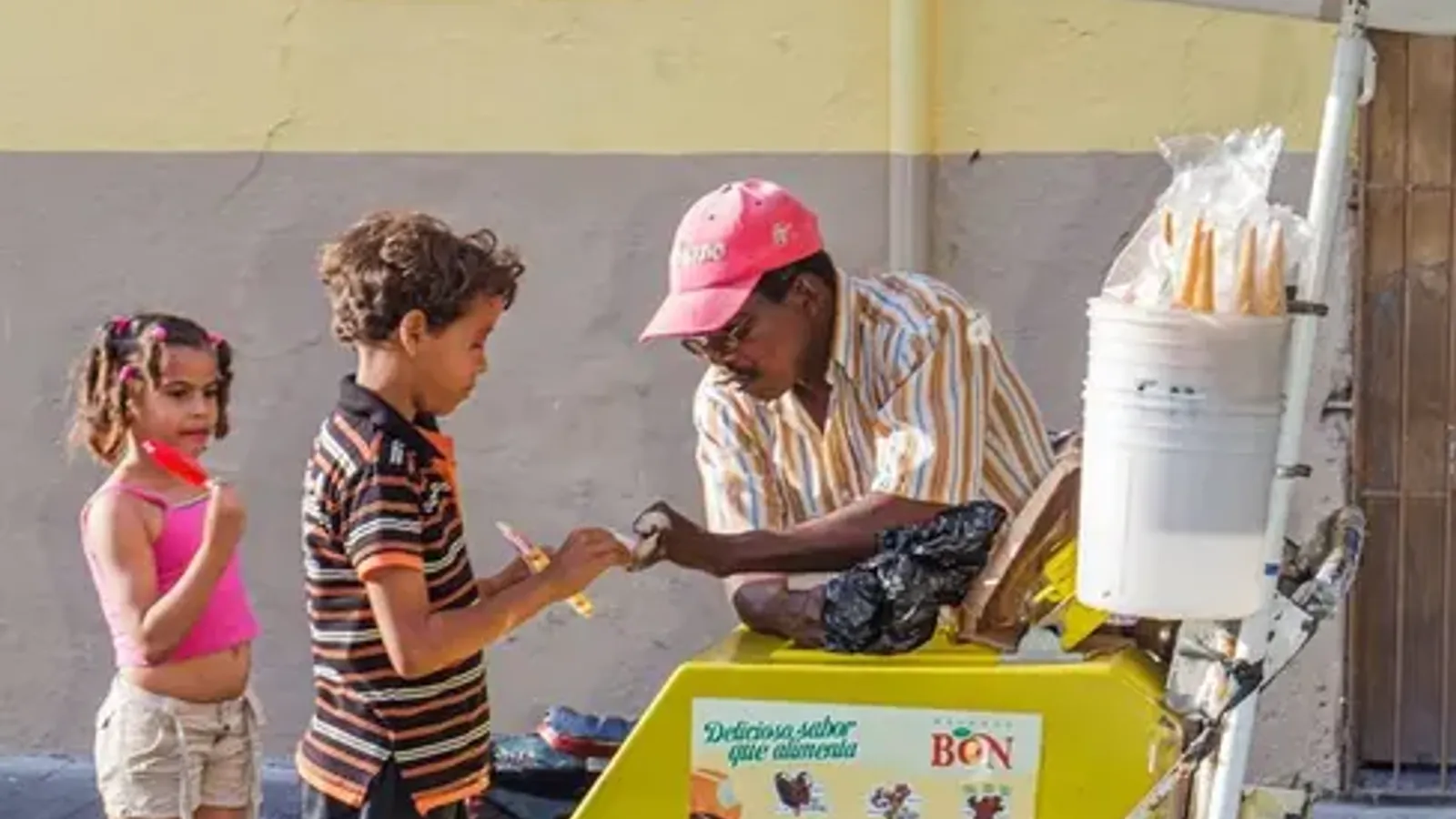 Heladero dominicano empujando un carrito de helados por una calle de Santo Domingo